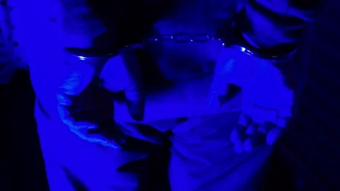 A suspect&amp;#039;s handcuffed hands under flashing police lights during arrest Stock Footage 318835302