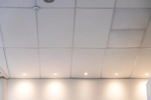 Suspended ceiling made of square plasterboard slabs with built-in round LED l Stock Photos