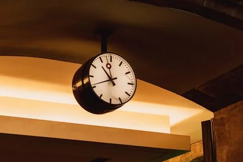 Suspended circular wall clock displaying hour and minute hands, black and w.. Stock Photos
