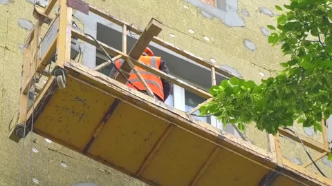 Suspended construction platform with workers moving along the facade Stock Footage 346804549