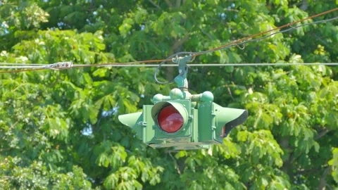 Suspended traffic light shaking in high wind during summer storm 動画素材 338263293