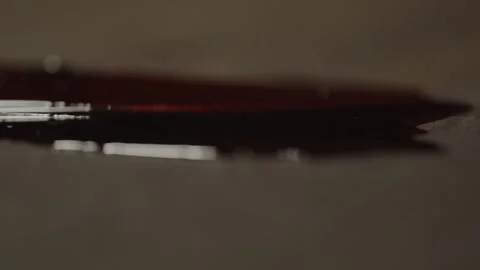 Suspenseful macro focusrack of a pool of blood with a sharp blade laying Stock Footage 278212666