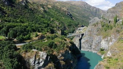 Suspension Bridge and canyon with two kayak steaming down the river. Famous C Video stock 127828242