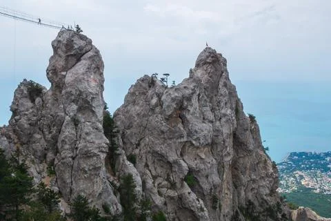 Suspension bridge connesting two mountain peaks. Stock Photos