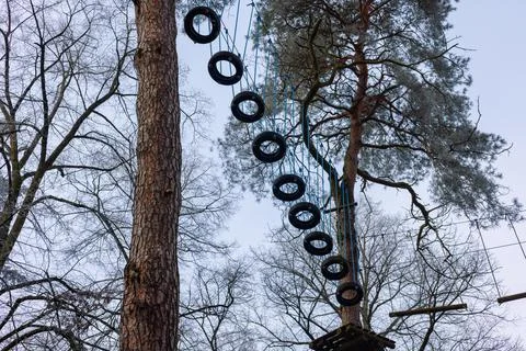 Suspension bridge high in the trees of the rope park. A bridge made of old .. Stock Photos
