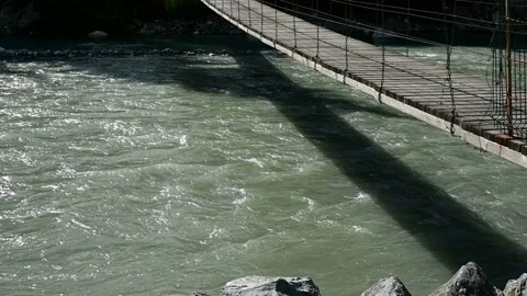 Suspension bridge over the course of the mountain river 4k Stock Footage 137171239