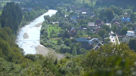 Suspension bridge over a mountain river in village Stock Footage 67390664