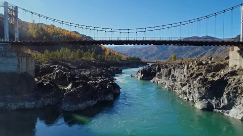 Suspension bridge over the mountain river Видео 122637883