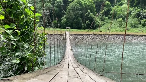 Suspension bridge over a mountain river Stock Footage 150665264