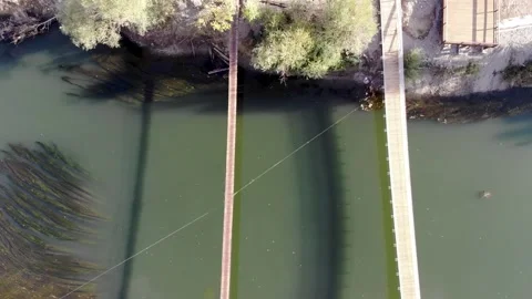 Suspension bridge over the river Stock Footage 144976567