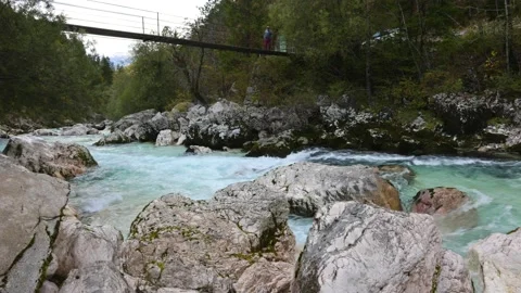 A suspension bridge spans the Soca River in the Julian Alps in Triglav National  Stock Footage 169038178