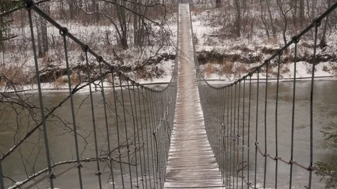Suspension pedestrian bridge over the river in winter in Russia 4K Video stock 127523341