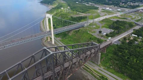 Suspension road bridge &amp; another cantilevered bridge side-by-side on the shore. Stock Footage 320247456