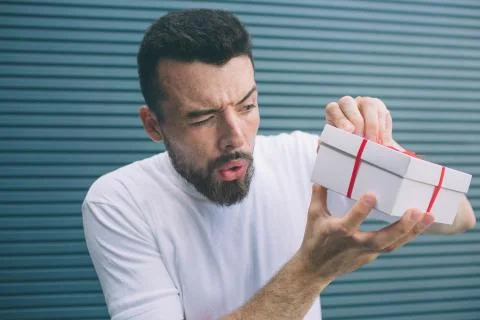 Suspicious man is trying to open box to see what is there. He doesn't want to Stockfoto's