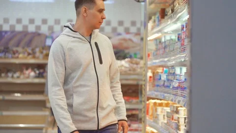 A suspicious middle-aged man opens a bottle of food store Stock Footage 91069007