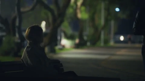 Suspicious package is given to female agent by man in leather jacket in a park Stock Footage 310375552