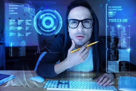 Suspicious programmer touching his chin while looking at the transparent screen Stock-Fotos