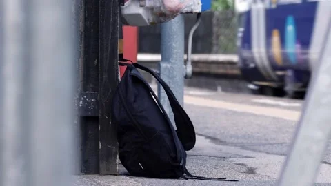 Suspicious rucksack left on railway platform as train goes by Stock Footage 196887982