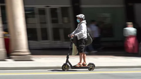Sustainable mobility, a man goes to work with an electric scooter in Genoa Stockbeeldmateriaal 155397914