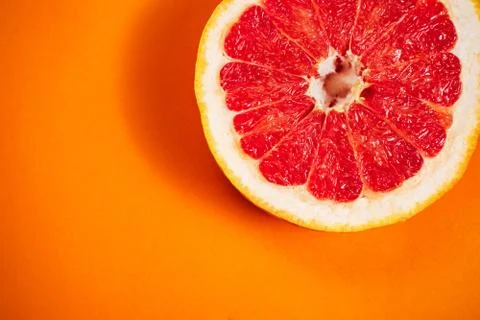 Сut grapefruit on the orange background. Stock Photos