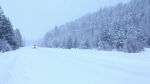 SUV car with rooftop cargo box driving on snow covered road in winter Stock Footage 107053790