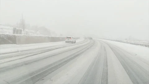 SUV car sliding out of control on highway in snow storm Stock Footage 143786418