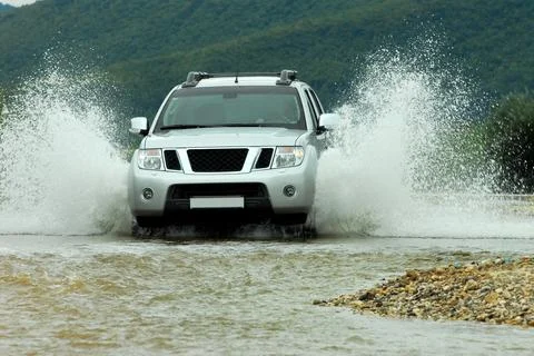 SUV crosses the river 库存照片