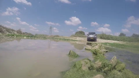 SUV crosses stream splashing the camera Stock Footage 82416002