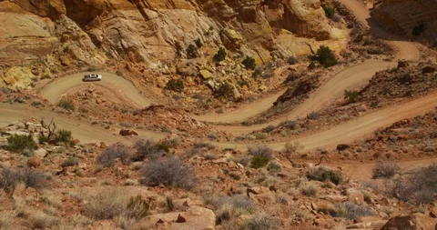 SUV  descending  Burr Trail Switchbacks into the colorful Strike Valley, Utah. Stock Footage 124024152