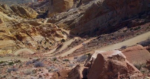 SUV descending Burr Trail Switchbacks into the colorful Strike Valley, Utah. Stock Footage 124075420