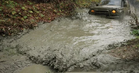 An SUV drives into a puddle at high speed off-road Stock Footage 245309924