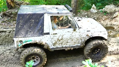 SUV drives uphill through the mud in the forest Stock Footage 171469497