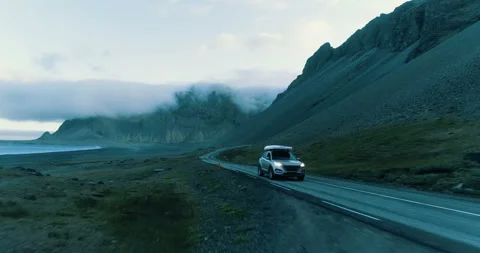 SUV driving along highway. Mountain peaks and meadows Stock Footage 95125345