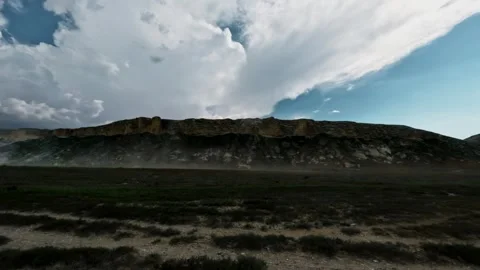 SUV driving off-road through rugged terrain with dramatic clouds overhead Stock Footage 340956435