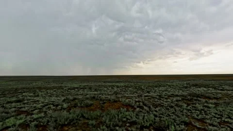 SUV driving off-road through rugged terrain under dramatic cloudy sky Stock Footage 340956750