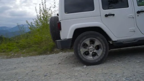 SUV driving through forest in mountains Stockbeeldmateriaal 82444297