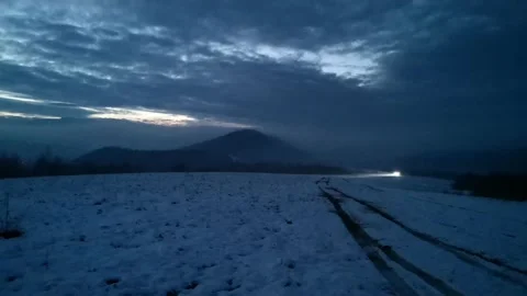 SUV driving through mountainous area on a winter foggy evening Video stock 231003974