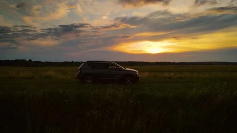SUV driving through open agricultural field terrain. Unrecognizable woman Stock Footage 303633702