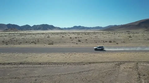 SUV With Dust Trail Across Desert Plain - Aerial Side Tracking, Sesriem, Namibia Stock Footage 346540396