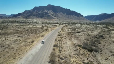 SUV With Dust Trail on Mountain Road - Aerial Follow Shot, Naukluft, Namibia Stock Footage 346540378
