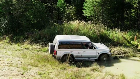 The SUV got stuck in the mud. He's trying to leave, but he can't. Skidding on Stock Footage 196850170