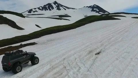 SUV on large wheels rides in peas in the snow in Kamchatka High quality HD Stock Footage 142390124