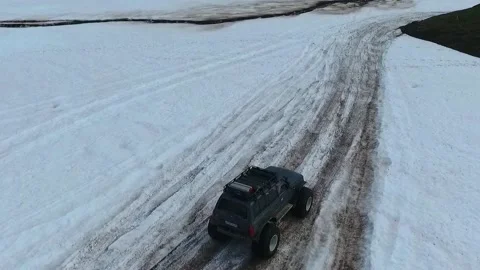 SUV on large wheels rides in peas in the snow in Kamchatka High quality HD Stock Footage 142390251