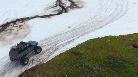 SUV on large wheels rides in peas in the snow in Kamchatka High quality HD Stock Footage 142390267