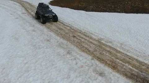 SUV on large wheels rides in peas in the snow in Kamchatka High quality HD Stock Footage 142390350