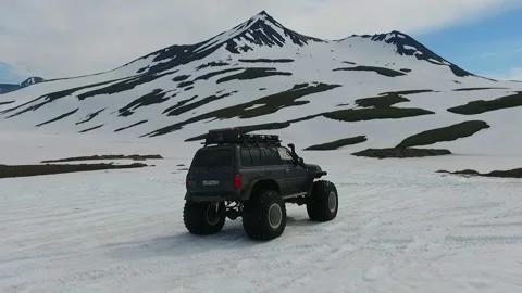 SUV on large wheels rides in peas in the snow in Kamchatka High quality HD Stock Footage 142390396