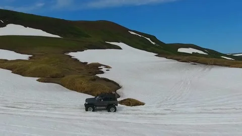 SUV on large wheels rides in peas in the snow in Kamchatka High quality HD Stock Footage 142390657