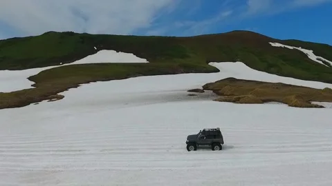 SUV on large wheels rides in peas in the snow in Kamchatka High quality HD Stock Footage 142390705