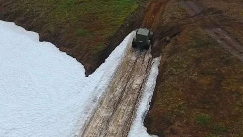 SUV on large wheels rides in peas in the snow in Kamchatka Stock Footage 142390832