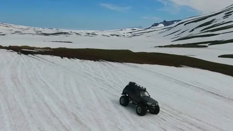 SUV on large wheels rides in peas in the snow in Kamchatka High quality HD Stock Footage 142391032